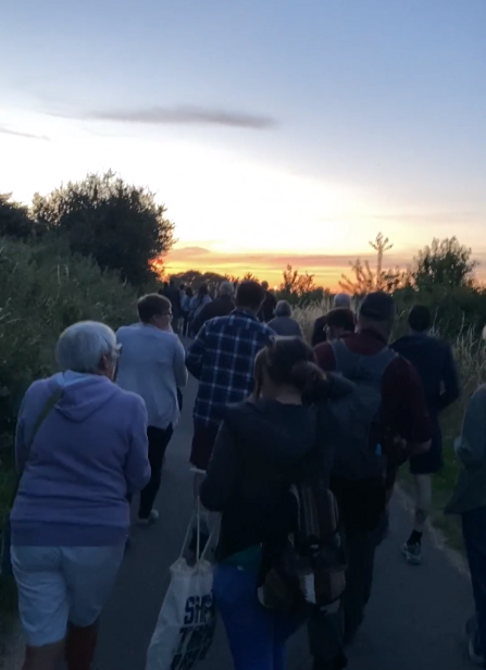 People walking through Stockwood Open Space at sunset