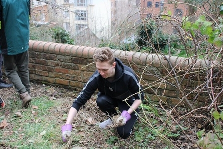 Kyle, a young volunteer, working in the garden at Great George Street