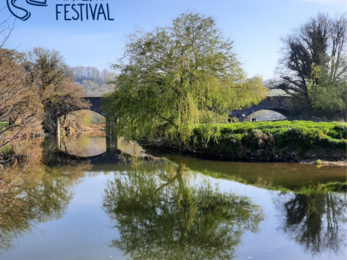 Wild Waters Festival logo on a river scene