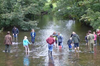 children and adults river dipping 