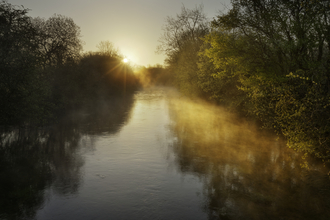 Sun rise over a misty river