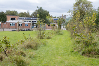 Woodlands Academy building and green space outdoors 