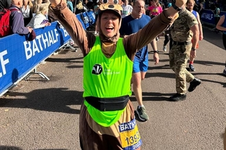 A woman in a beaver costume cheering at the finish line of a race