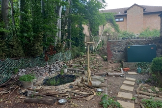 Building a pond and bird feeder in a public space, paving slabs and tools on show