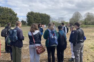 Young people standing in a circle talking at Green Shoots