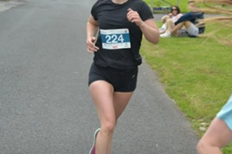 Anna smiling to the camera as she takes place in a running challenge