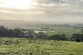 Looking across the North Somerset Levels and Moors with sunlight coming through the clouds