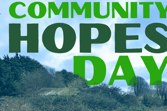 The words 'Green Shoots at Grow Wilder Community Hopes Day' on a blue sky background, and slightly hidden by a tree landscape 