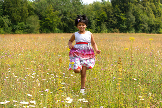 Girl running through meadow