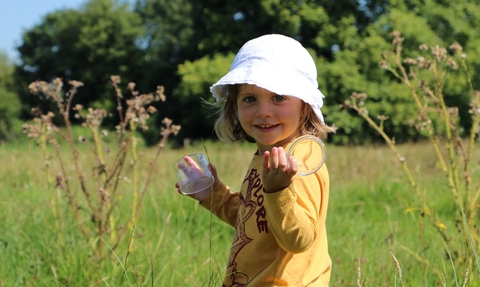 A toddler with a bug pot