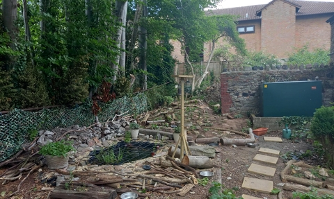 Building a pond and bird feeder in a public space, paving slabs and tools on show