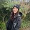 Charlie wears an Avon Wildlife Trust branded hat and coat, and is stood in a wooded area, smiling at the camera