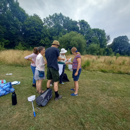 A group of people gathered to look at insects which have been caught in their nets during a monitoring survey