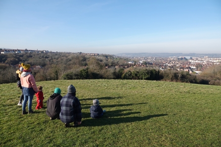 A My Wild Child group sit in a field and admire the landscape