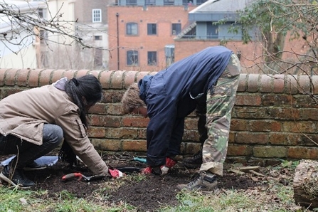 Young volunteers, Molly and Xinyu, working in the garden at Great George Street
