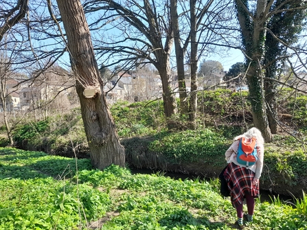 Alison Harper next to stream and river bank