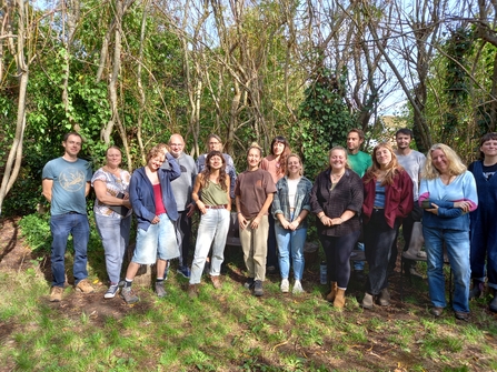 A group of 15 people in a willow circle in nature