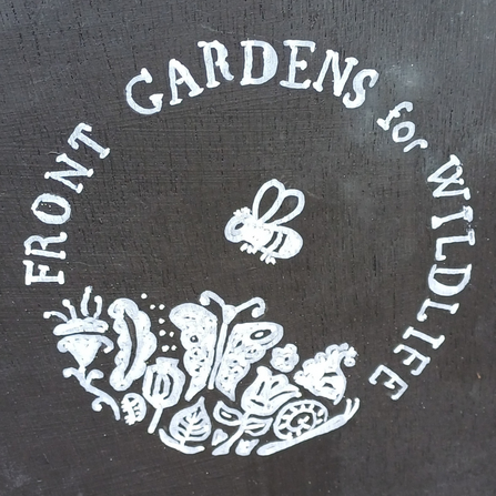 Blackboard sign with white logo, text says 'front gardens for wildlife' in a circle with a bee picture in teh middle and flowers and butterflies below