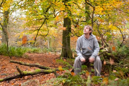 Man sitting in an autumnal woodland