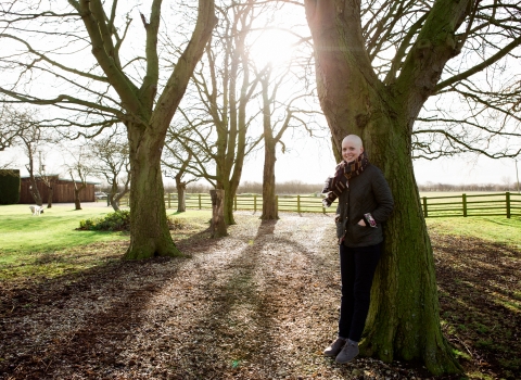 Michelle stands beside a tree