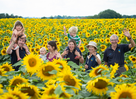 Family with Nicholas Watts' younger grandchildren in sunflower field