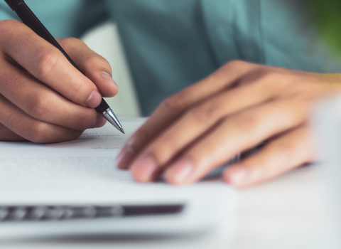 A person writing a letter