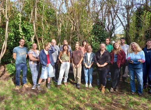 A group of 15 people in a willow circle in nature