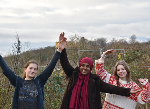 Three young people with hands in the air at Green Shoots