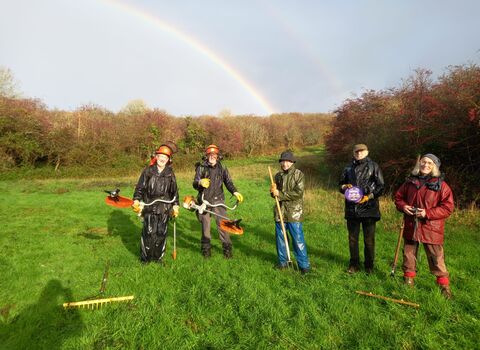 Volunteers on a work day with a double rainbow